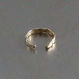 Beaten ear cuff in yellow gold seen from the front, open hammered band