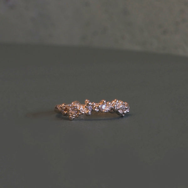 Rockpool curved band in gold, textured metal set with small pale stones