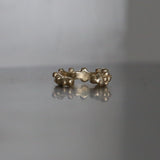 Seafoam ear cuff in yellow gold, textured band on a pale surface